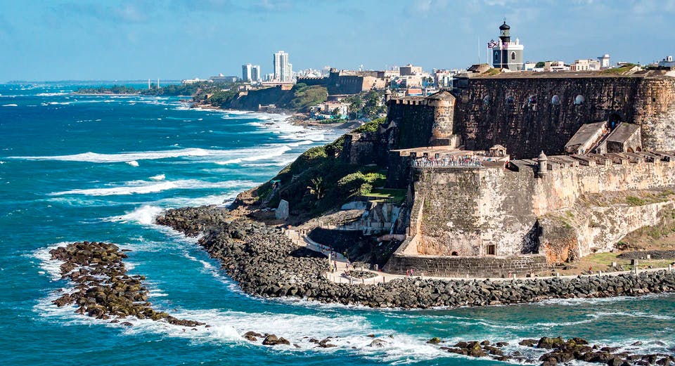 Fortaleza colonial frente a la playa y ciudad al fondo