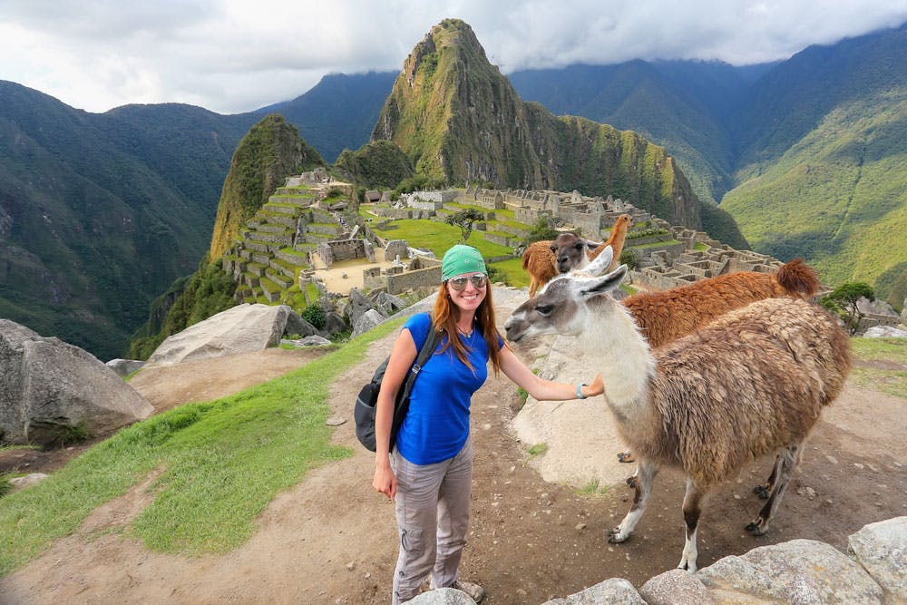 Viajera junto a dos llamas en Machu Picchu