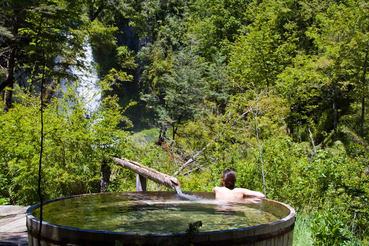 Persona bañandose en terma en medio del bosque de pucón