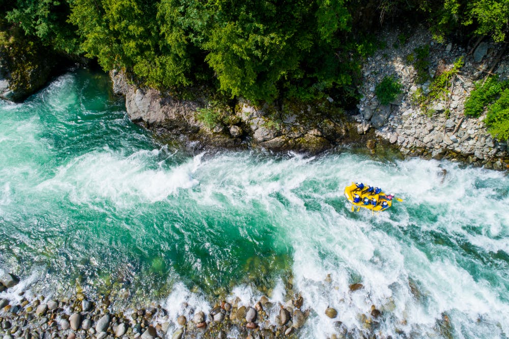 Personas realizando rafting en medio de río en Pucón