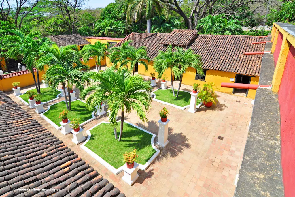 Edificio colonial amarilla entremedio de palmeras