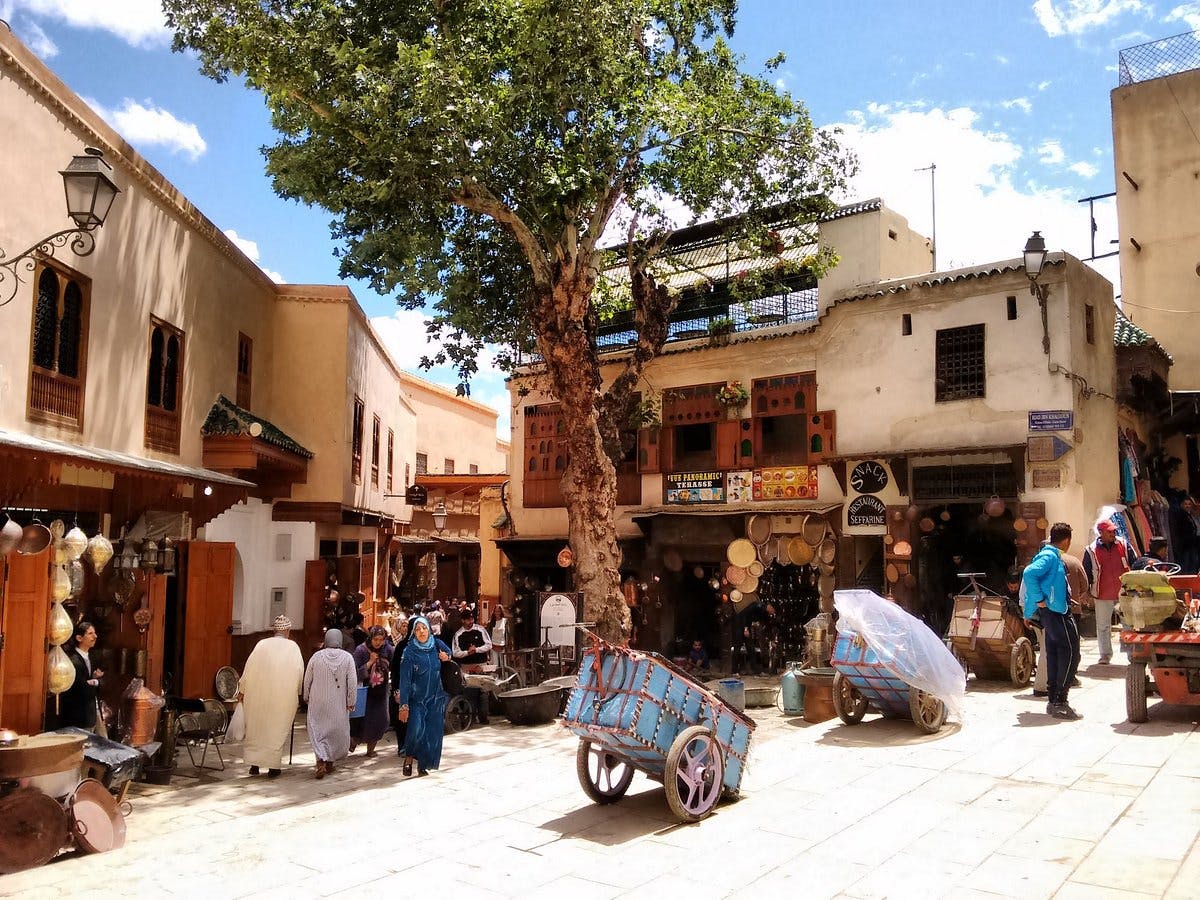 Plaza concurrida en ciudad con estilo árabe en Fez