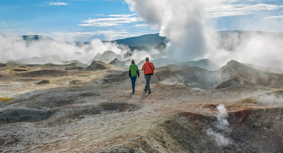 Dois viajantes a fazer trekking pelos géisers na Bolívia